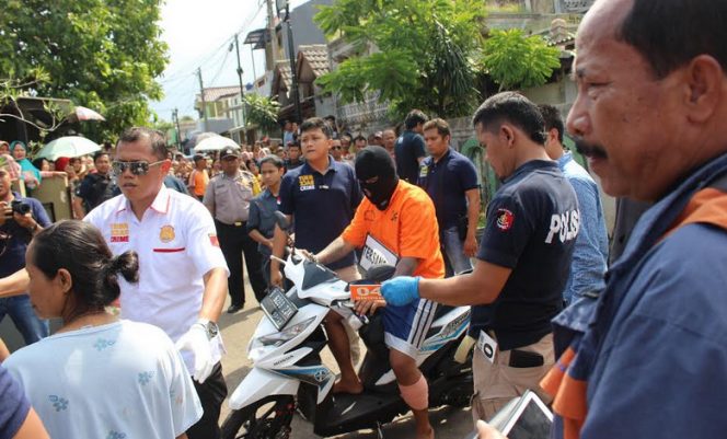 
					Pelaku pembunuhan  saat melakukan reka adegan dengan pengawalan polisi di Jalan Mawar, Kedaung, Pamulang, Tangerang Selatan, Rabu (31/5).