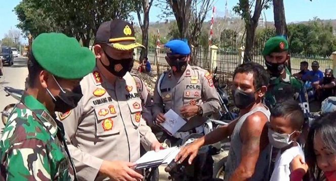 
					Kapolres Mabar AKBP Bambang Hari Wibowo membagikan masker sumbangan Presiden Jokowi kepada warga Labuan Bajo. (Ist)