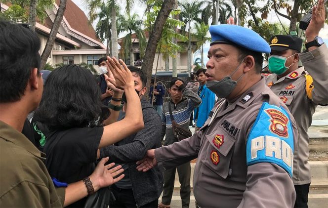 
					Seorang anggota Provost Polresta Pontianak mencoba meredam aksi protes mahasiswa saat seorang mahasiswa diamankan dalam unjuk rasa menolak RKHUP di gedung DPRD Kalimantan Barat, Rabu (6/7/2022) sore. (Foto Adi Saputro)