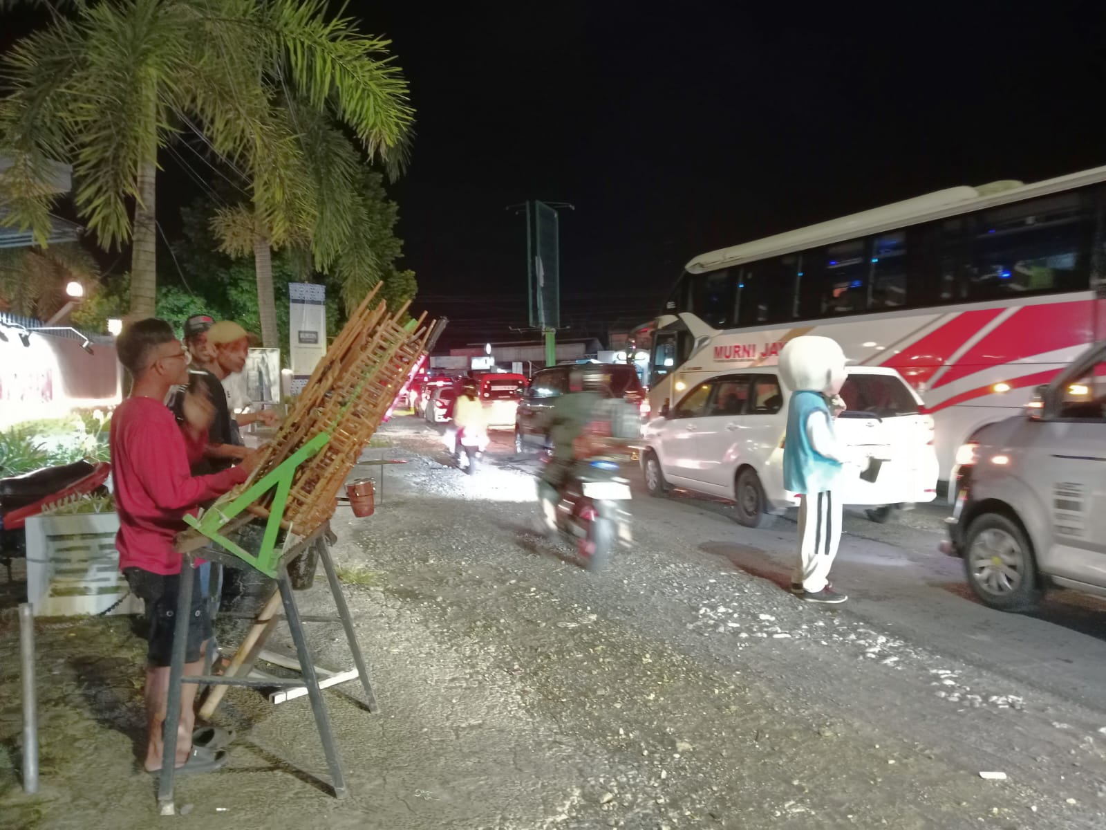 Aksi pemuda memainkan musik thek-thek di Ajibarang menghibur pemudik yang terjebak macet saat arus balik Lebaran, menghadirkan suasana hangat di tengah kepadatan jalan. (Foto: RN/Kus)