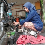 Aksi mekanik perempuan di Banyumas mengenakan kebaya saat bekerja viral di Hari Kartini. Kisah inspiratif ini jadi bukti perempuan mampu menembus batas profesi. (Foto: ReportaseNews/Kus)