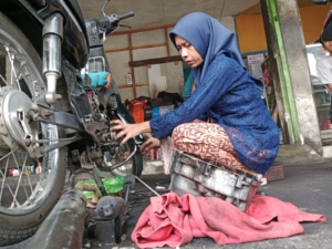 Aksi mekanik perempuan di Banyumas mengenakan kebaya saat bekerja viral di Hari Kartini. Kisah inspiratif ini jadi bukti perempuan mampu menembus batas profesi. (Foto: ReportaseNews/Kus)