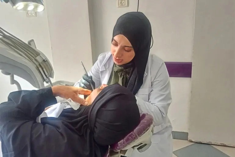 Dokter gigi Liza Hassouna, sedang menangani pasien di kamp Nuseirat Gaza, Palestina. (Foto: Al Jazeera/Lina Abuzayed)