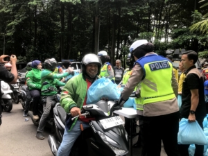 Polda Metro Jaya membagikan sembako dan voucher belanja kepada pengemudi ojek online dalam program Jumat Peduli di Jakarta. Bantuan disambut antusias para driver ojol. (Foto: ReportaseNews/Vira)