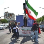 Sejumlah perempuan Iran kibarkan bendera kenegaraannya. (Foto: WANA via Reuters/Majid Asgaripour)
