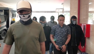 Bripka Dedy Wiratama (baju batik), mantan anggota Brimob yang diduga membekingi kampung narkoba Gang Langgar di Samarinda, dibawa ke Bareskrim Polri Jakarta untuk menjalani pemeriksaan lanjutan. (Foto: ReportaseNews/Tama)
